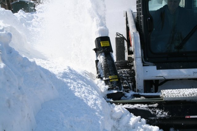 Hydramax Snow Blower blowing snow behind.